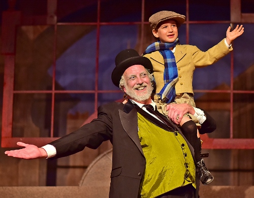 Ebenezer Scrooge (Jeff Stockberger), left, lifts Tiny Tim (Ashton Curry) in Beef & Boards Dinner Theatre’s one-hour production of 'A Christmas Carol'.