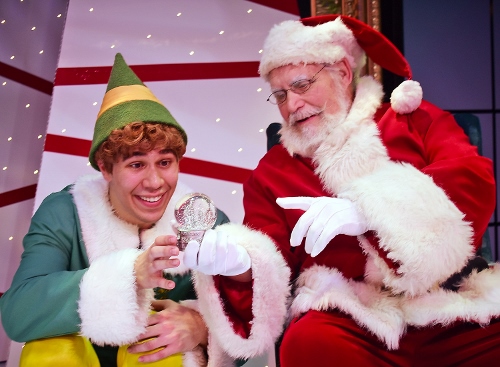 After confirming to Buddy (Dan Bob Higgins), left, that he’s human, Santa gives him a snow globe to show him what the Empire State Building, where his father works, looks like in Beef & Boards Dinner Theatre’s production of Elf, The Musical, now on stage through Dec. 31.