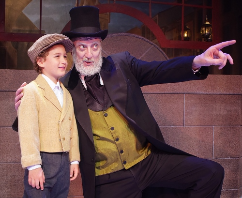 After finding redemption on Christmas Day, Ebenezer Scrooge (Jeff Stockberger) enjoys some time with Tiny Tim (Ashton Curry) in Beef & Boards Dinner Theatre’s production of A Christmas Carol, on stage select dates through Dec. 21.