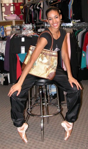 Kimberly is wearing Black Pants by Body Wrappers, Style 701, $24.99; and a New York City Ballet Logo Tee Shirt, Style 6239, $28.99. She is carrying a Galleria Enterprises Degas Bag, Style 70204, $26.99. Available at <a href='http://www.onstagedancewear.com'>OnStageDancewear.com</a>.