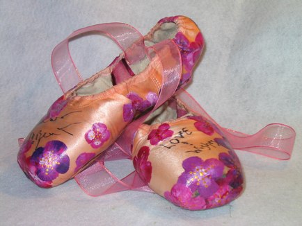 An example of a pair of pointe shoes (Autographed by former member of the New York City Ballet Diana McBrearty and, painted by Michelline Coonrod)