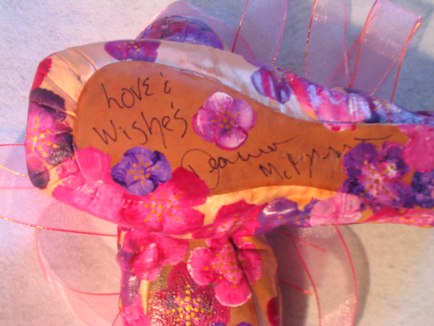 An example of a pair of pointe shoes (Autographed by former member of the New York City Ballet Diana McBrearty and, painted by Michelline Coonrod)