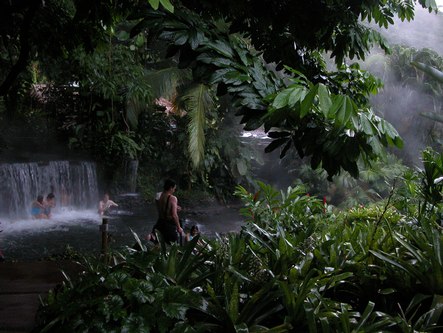 People sitting in a waterfall at the Arenal Resort